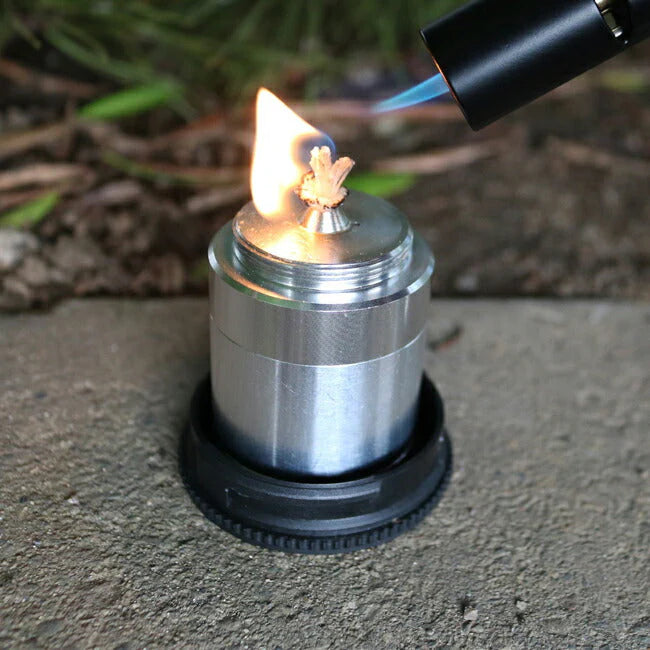 F Plus Duralumin Oil Candle — lit, outdoor