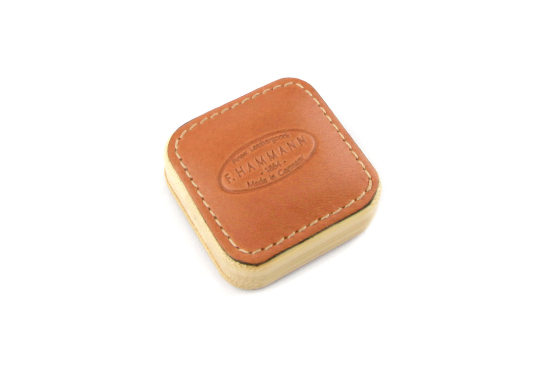 Close-up angled view of the F. Hammann 5205 Coxorange Leather Tape Measure, detailing the embossed 1864 logo.