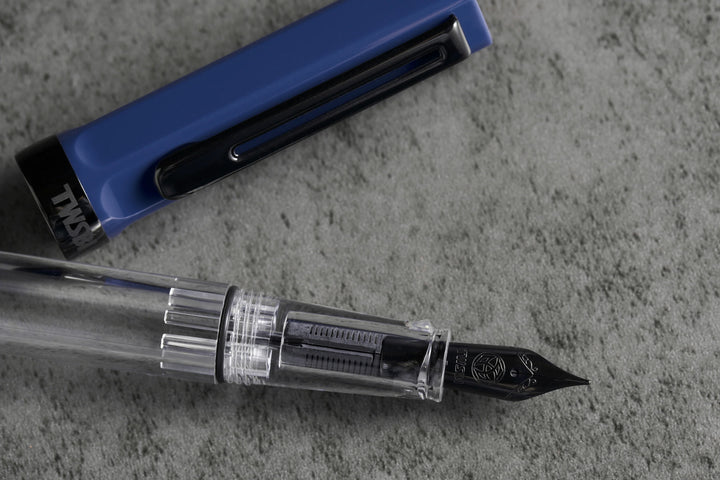Close up of TWSBI ECO Fountain Pen – Slate Blue Onyx, featuring the nib, on a textured surface