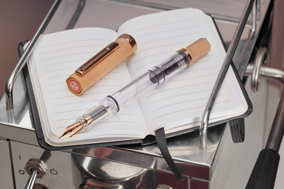 TWSBI ECO Fountain Pen – Caffe Bronze on a notebook with a metallic background