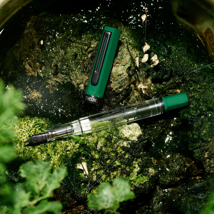 TWSBI ECO Fountain Pen – Irish Green Onyx on a textured surface with greenery.