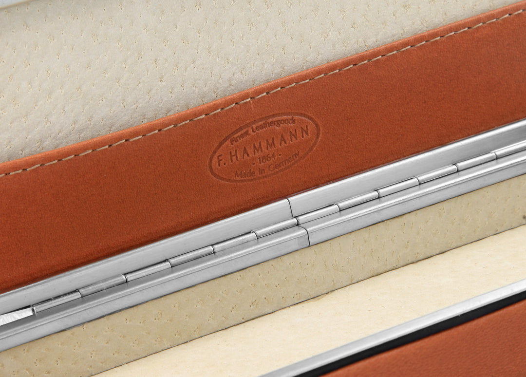 Macro detail of the F. Hammann 1864 heritage logo embossed on the integrated Coxorange leather slip compartment inside the lid.