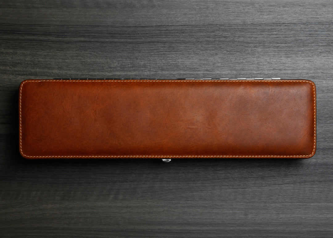 Top-down photograph of the closed F. Hammann 3976 Ruler Box in rich Coxorange leather on a dark wood grain surface.