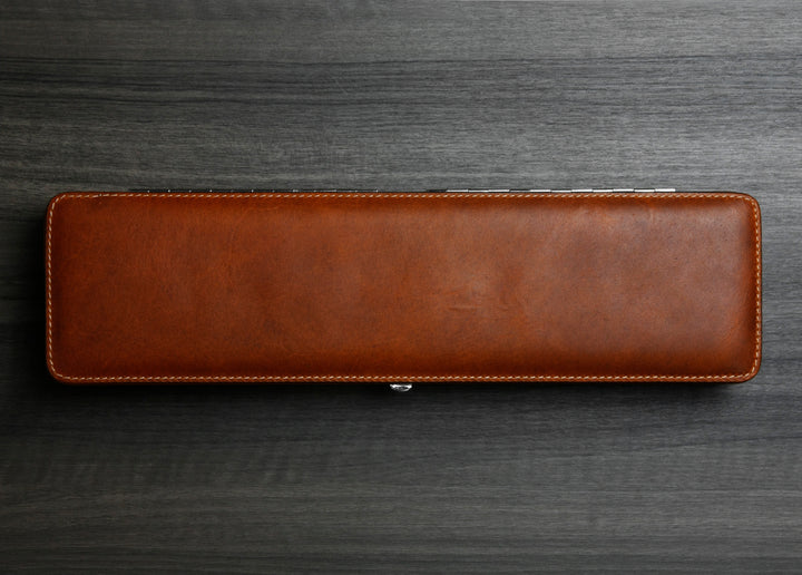Top-down photograph of the closed F. Hammann 3976 Ruler Box in rich Coxorange leather on a dark wood grain surface.