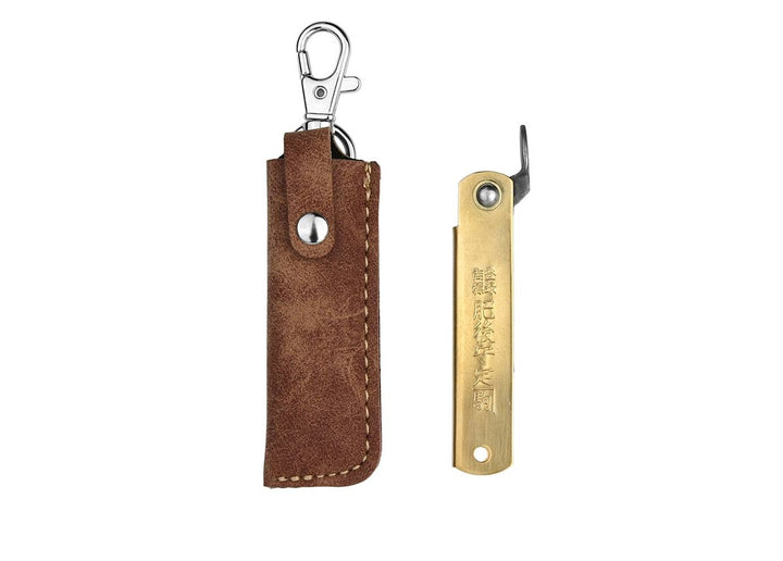 Closed Higonokami Brass S Japanese pocket knife next to its included brown synthetic leather carry pouch.