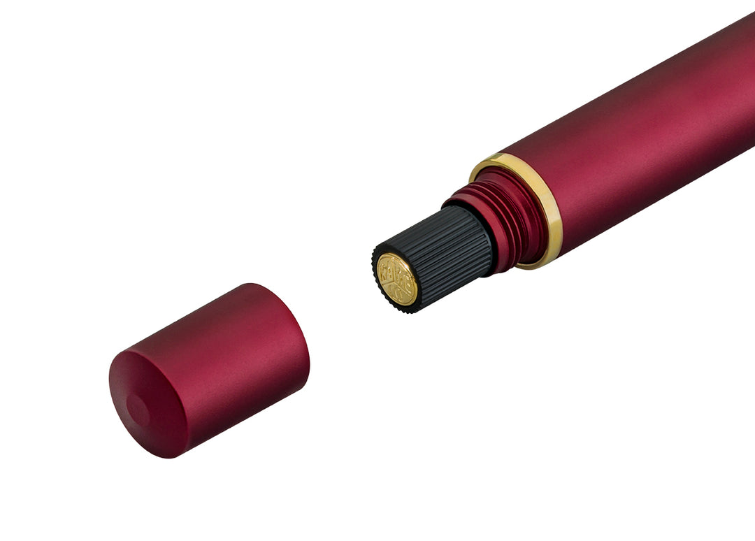 Close-up of the removed anodised red blind cap and black ribbed piston turning knob featuring a gold Kaweco logo on the back of the Kaweco Piston Sport AL Fountain Pen in Bordeaux.