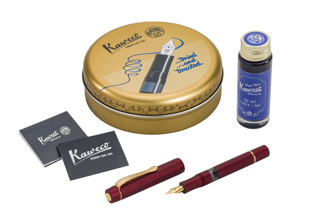 Kaweco Piston Sport AL Fountain Pen Starter Set in Bordeaux, featuring the open anodised red pen, a classic round gold Kaweco tin, instruction leaflets, and a 32 ml bottle of Kaweco Royal Blue ink.