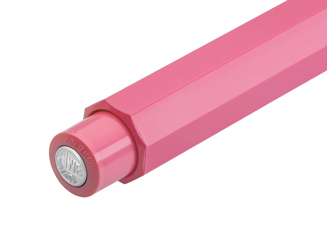 Close-up of Kaweco Skyline Sport Pink push button featuring silver logo medallion, "Made in Germany" engraving, and faceted barrel.