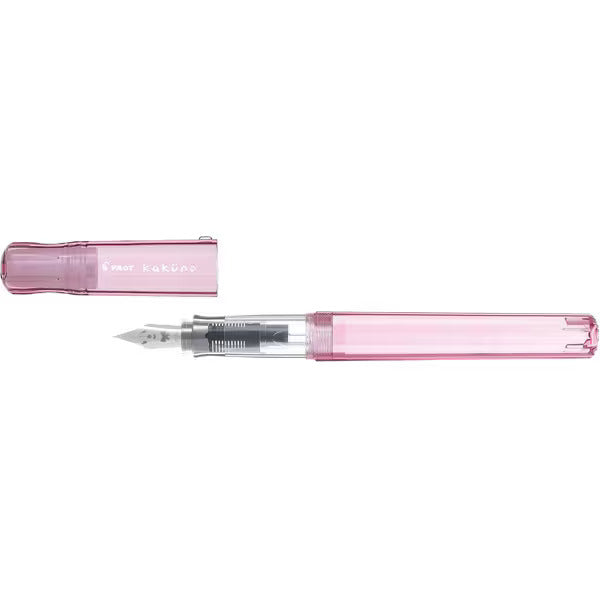 Uncapped Pilot Kakuno Transparent Pink fountain pen showing the clear grip section and Girl character steel nib.