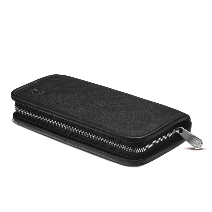 Angled profile of the closed Sonnenleder Walser Leather Pen Case in Black, highlighting the slim, protective zip-around design and premium high-contrast polished silver-tone metal zipper.