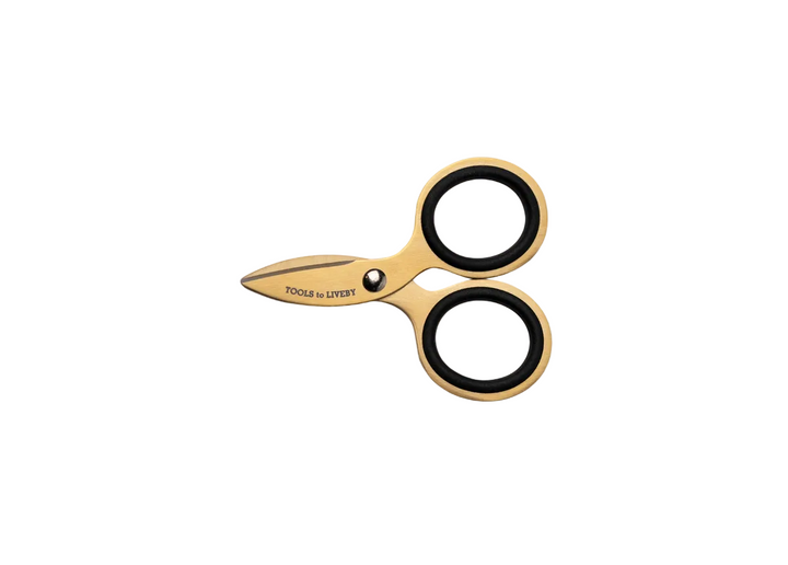TOOLS to LIVEBY 3-inch gold pocket scissors fully closed and resting horizontally on a minimalist white background, showcasing the ultra-compact, micro-EDC Japanese stainless steel profile and striking golden finish.