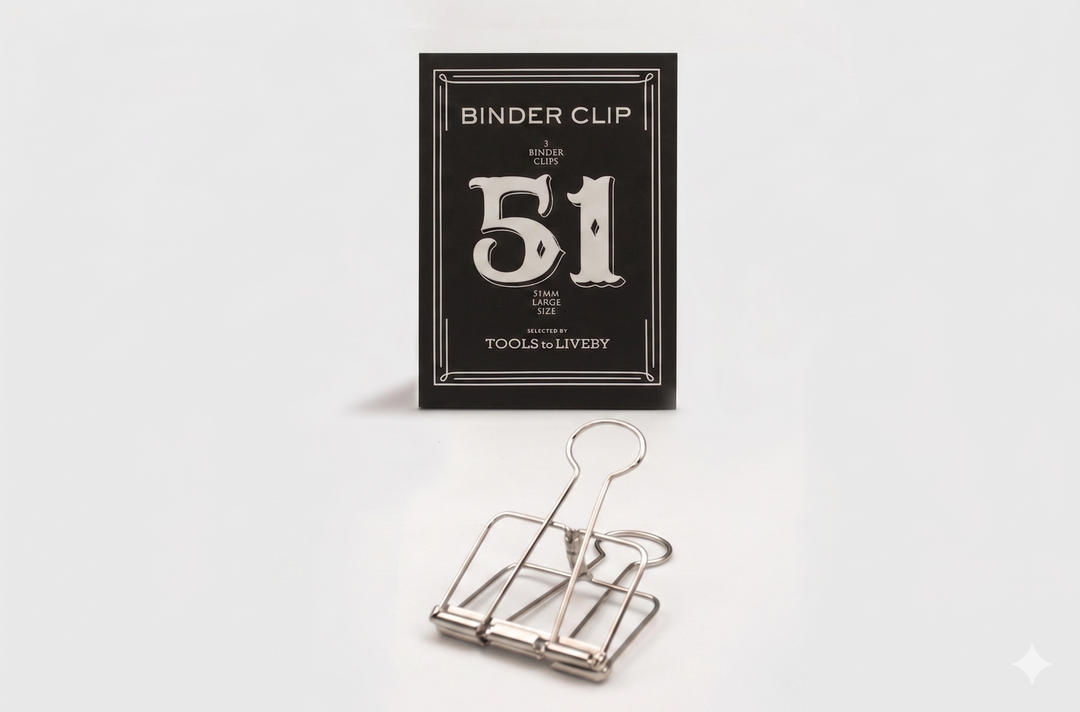 A large 51mm TOOLS to LIVEBY silver skeleton binder clip resting in front of its premium black packaging, which features a prominent silver foil-stamped number 51.