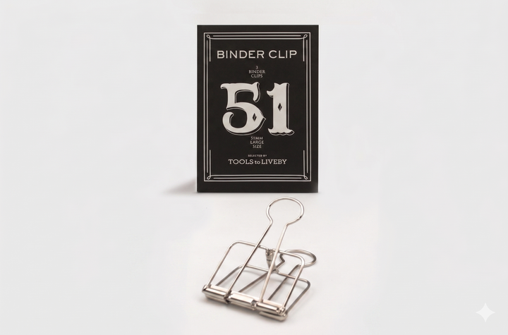 A large 51mm TOOLS to LIVEBY silver skeleton binder clip resting in front of its premium black packaging, which features a prominent silver foil-stamped number 51.