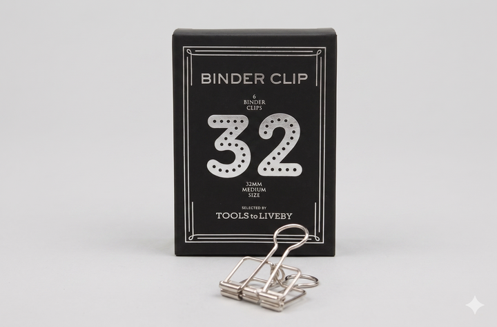 A medium 32mm TOOLS to LIVEBY silver skeleton binder clip displayed alongside its custom black paper box, highlighted by a dotted silver foil-stamped number 32.