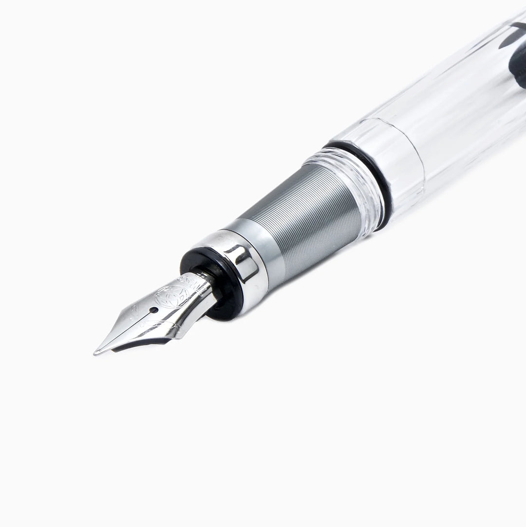 Macro product photograph focusing tightly on the front section of the uncapped TWSBI Diamond 580ALR Nickel Gray fountain pen. Set against a pure white background, it shows the precise detailing of the silver stainless steel Jowo nib and the finely machined texture of the matte nickel-gray ribbed aluminum grip.