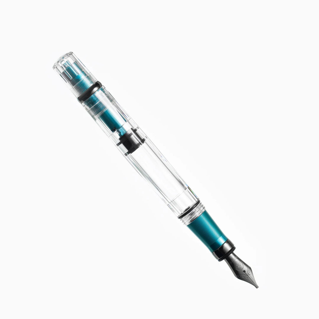Angled view of the uncapped TWSBI Diamond 580ALR Caribbean Blue fountain pen on a white background, highlighting the stealthy black titanium nib, ribbed blue aluminum grip, and clear demonstrator barrel.