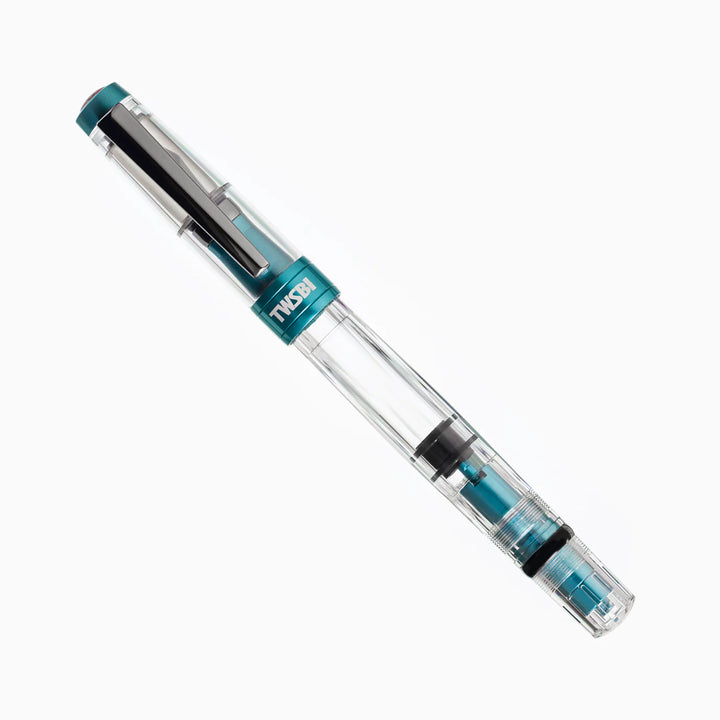Capped TWSBI Diamond 580ALR Caribbean Blue fountain pen angled against a white background, featuring the clear faceted resin barrel, stealth black titanium trim, and matte blue aluminum accents.