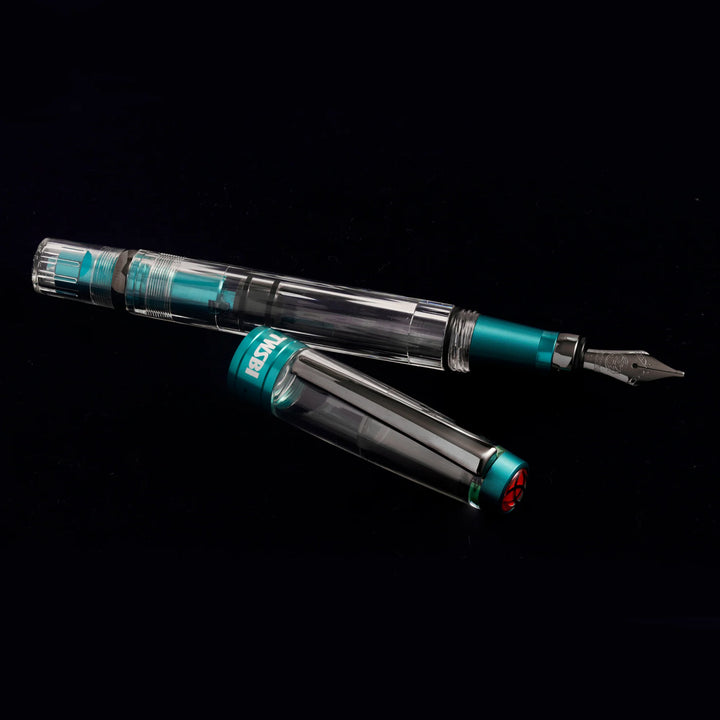 Floating view of the uncapped TWSBI Diamond 580ALR Caribbean Blue fountain pen over its cap on a black background, revealing the clear high-capacity ink reservoir, internal blue piston, and signature red finial logo.