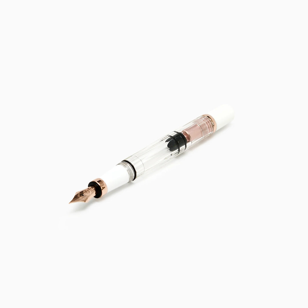Detailed profile view of the TWSBI Diamond 580 White Rose Gold II fountain pen without its cap, emphasizing the crystal-clear resin barrel, high-capacity piston mechanism, and elegant rose gold turning knob accents.