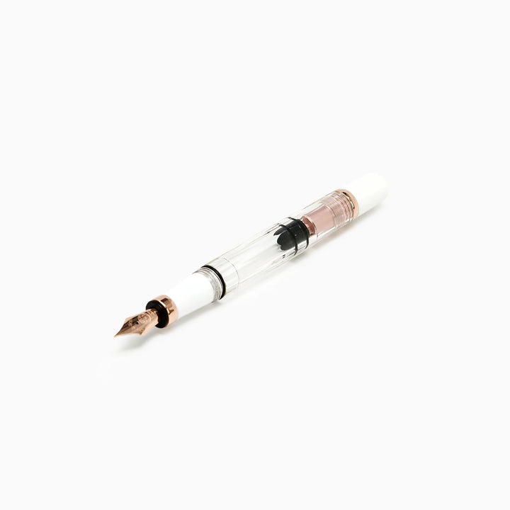 Detailed profile view of the TWSBI Diamond 580 White Rose Gold II fountain pen without its cap, emphasizing the crystal-clear resin barrel, high-capacity piston mechanism, and elegant rose gold turning knob accents.