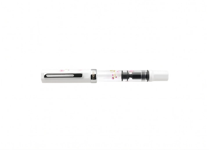 Horizontal profile view of the capped TWSBI ECO Cherry Blossom fountain pen, featuring silver trim, a clear printed barrel, and white accents.