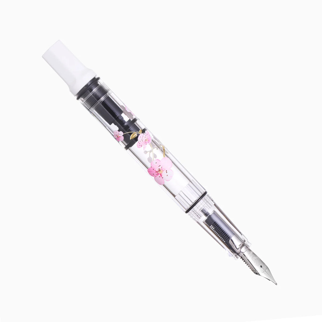 Uncapped TWSBI ECO Cherry Blossom piston-filler fountain pen on a white background, highlighting the clear floral barrel and stainless steel nib.