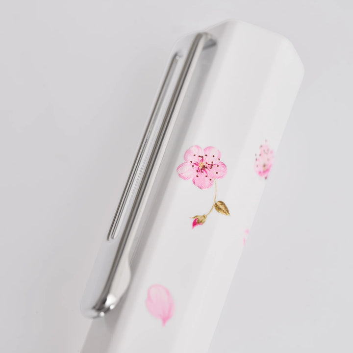 Close-up of the white hexagonal cap on the TWSBI ECO Cherry Blossom fountain pen, detailing the silver pocket clip and screen-printed pink floral motif.