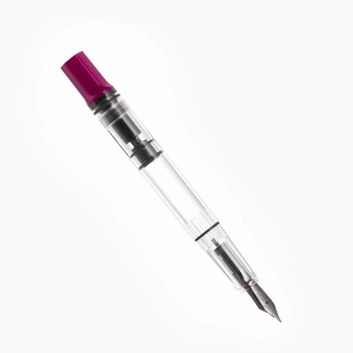 Uncapped, angled view of the TWSBI ECO Plum Onyx fountain pen resting on a seamless white background. The photograph highlights the dark onyx black-plated stainless steel Jowo nib, the clear high-capacity demonstrator barrel, and the distinct deep plum purple resin piston knob.