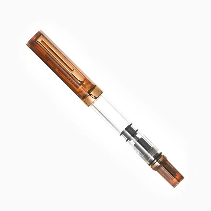 Angled product photograph of the fully capped TWSBI ECO Rootbeer Bronze fountain pen on a pure white background. The image clearly displays the warm translucent brown rootbeer resin cap and piston knob, the vintage bronze-plated pocket clip and cap band, and the crystal-clear ink barrel.