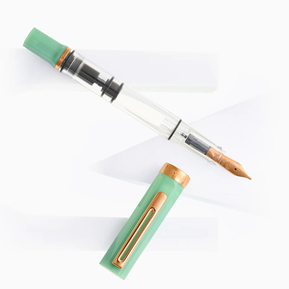 Uncapped TWSBI ECO Jade Jelly Bronze fountain pen and cap displayed diagonally on modern, angular white geometric props.