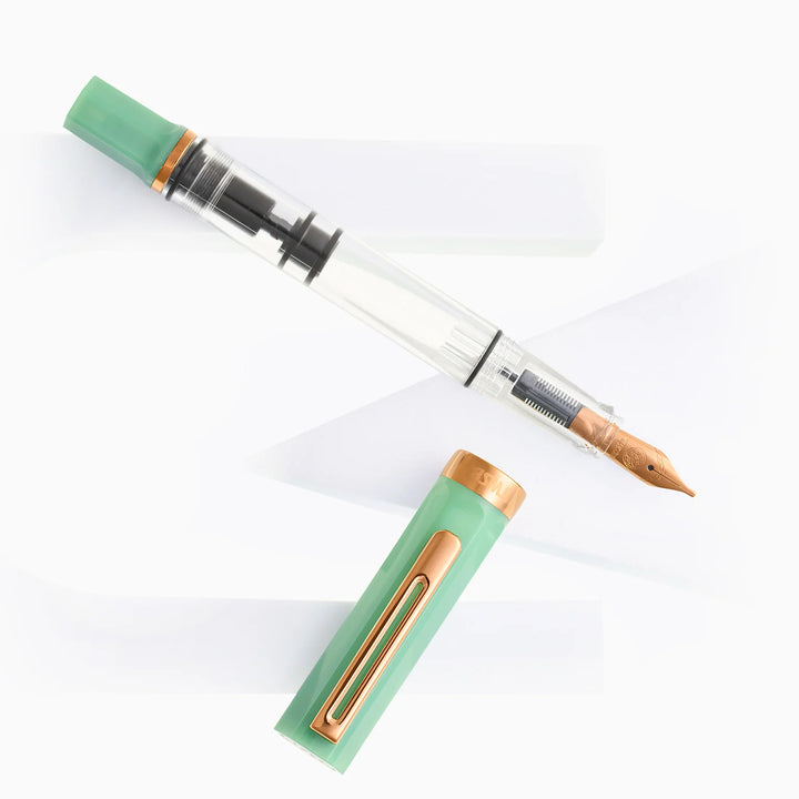 Uncapped TWSBI ECO Jade Jelly Bronze fountain pen and cap displayed diagonally on modern, angular white geometric props.