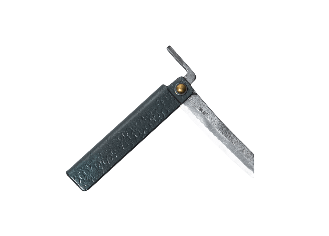 Partially open Tomita Higo knife featuring a black tsuchime hammered iron handle and a traditional profile Shirogami steel blade with Midareba pattern.