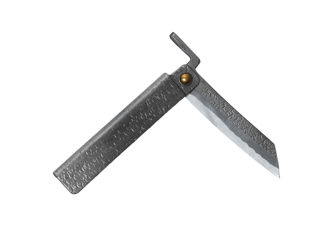 Partially open Tomita Higo knife featuring a silver tsuchime hammered iron handle and a traditional profile Shirogami steel blade with Midareba pattern.