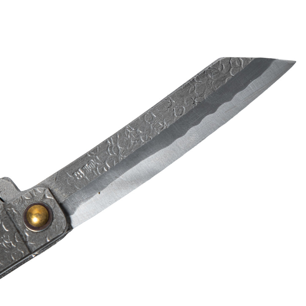 Macro close-up of the hand-forged Tomita blade, highlighting the traditional Higo profile, hammered spine, Japanese maker's mark, and characteristic Midareba wave pattern.