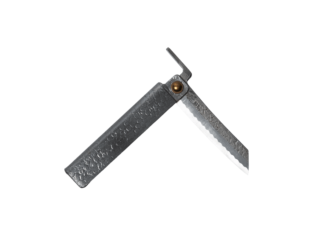 Partially open Tomita Higo knife featuring a silver tsuchime hammered iron handle and a traditional profile Shirogami steel blade with Midareba pattern.