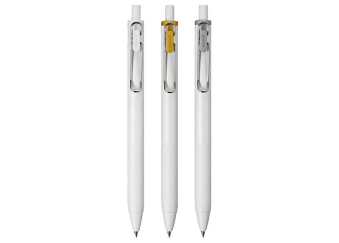 Studio lineup of the three Uni-ball One 0.38mm metallic gel pens showing White, Gold, and Silver wire clips.
