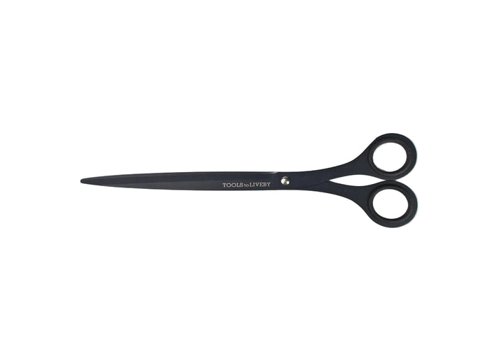 TOOLS to LIVEBY 9-inch matte black scissors fully closed and resting horizontally on a minimalist white background, showcasing the elongated Japanese stainless steel profile and anti-glue Teflon coating.