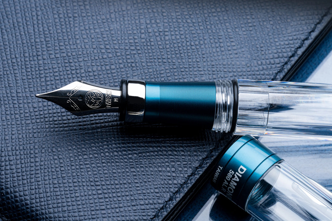 Close up of TWSBI Diamond 580ALR Fountain Pen – Prussian Blue on a textured surface