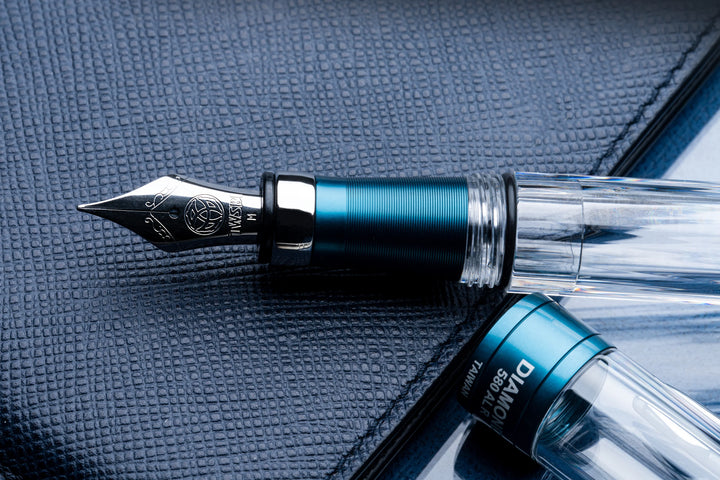 Close up of TWSBI Diamond 580ALR Fountain Pen – Prussian Blue on a textured surface