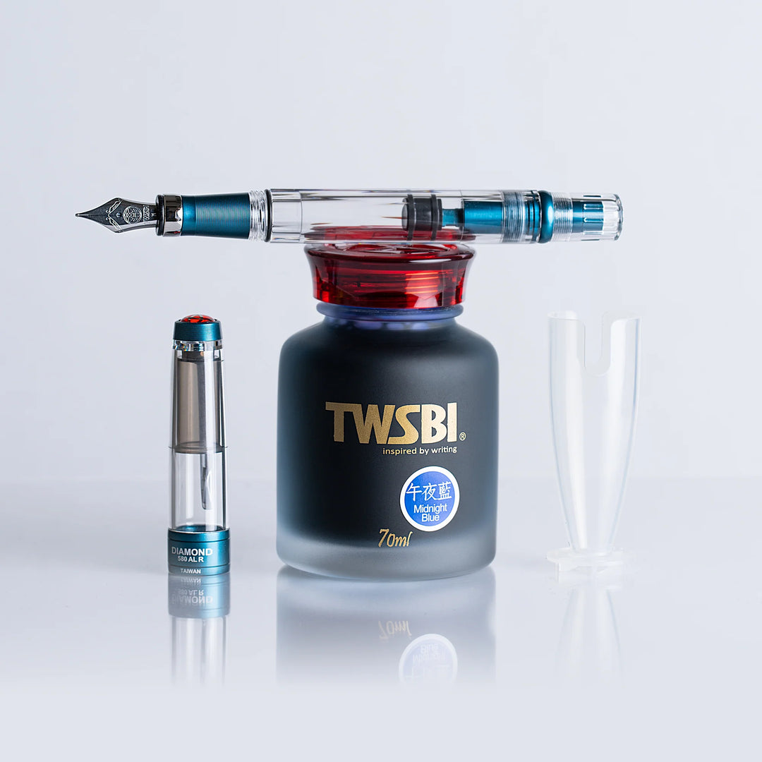 TWSBI ink bottle with TWSBI Diamond 580ALR Fountain Pen – Prussian Blue on a light gray background