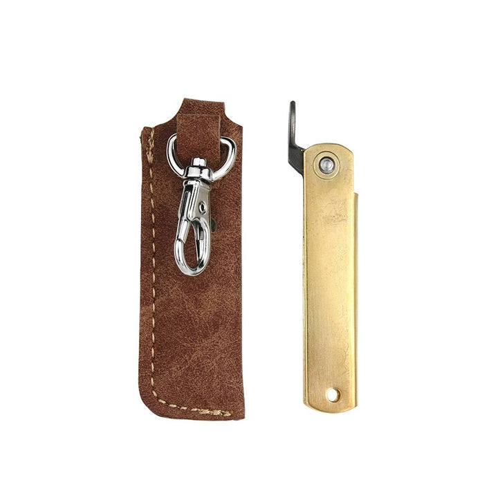 Rear view of the closed Higonokami Brass S pocket knife alongside the clip side of the synthetic leather sheath.