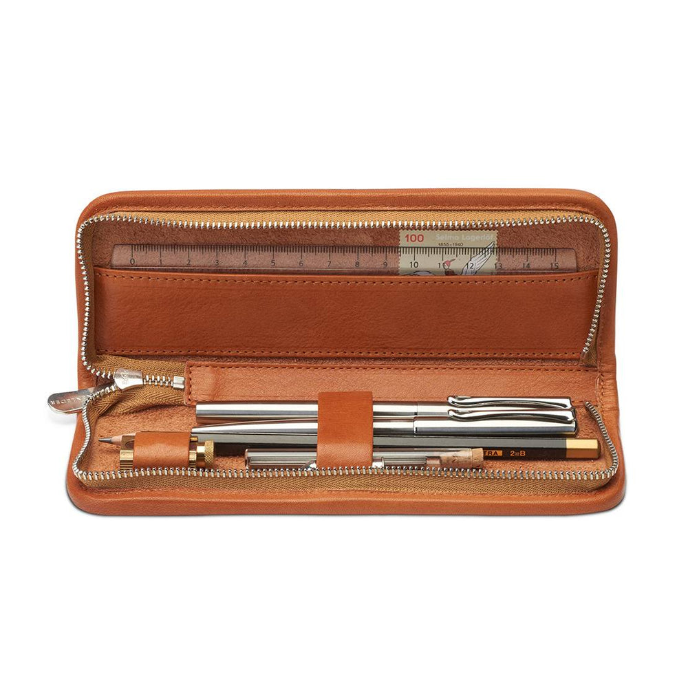 Interior layout of the open Sonnenleder Böll Leather Pencil Case in Natural, showcasing leather-covered loops securing pens and a sharpener, alongside a dedicated slip pocket holding a ruler and stamps.